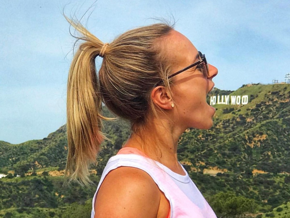 a person posing with the hollywood sign on our griffith park hike
