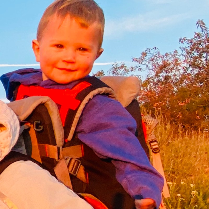 a little boy that is sitting in the grass