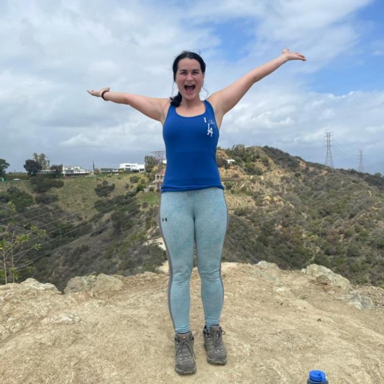 a woman standing on a dirt road