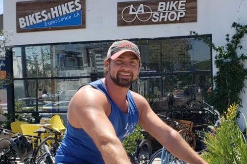 a person with a bicycle in front of a building