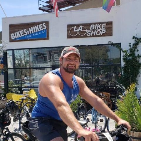 a person with a bicycle in front of a building