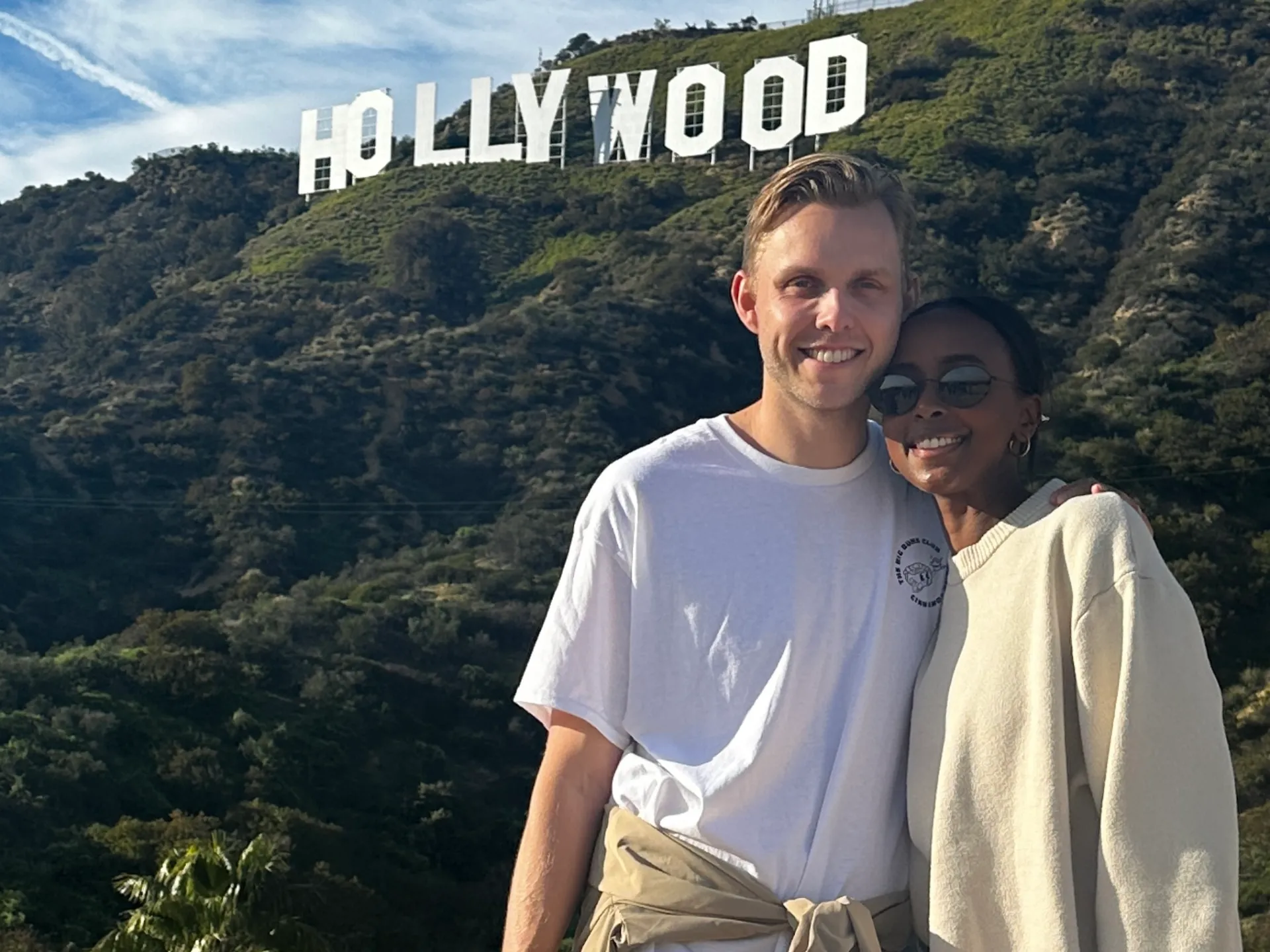 a man and a woman standing in front of a mountain