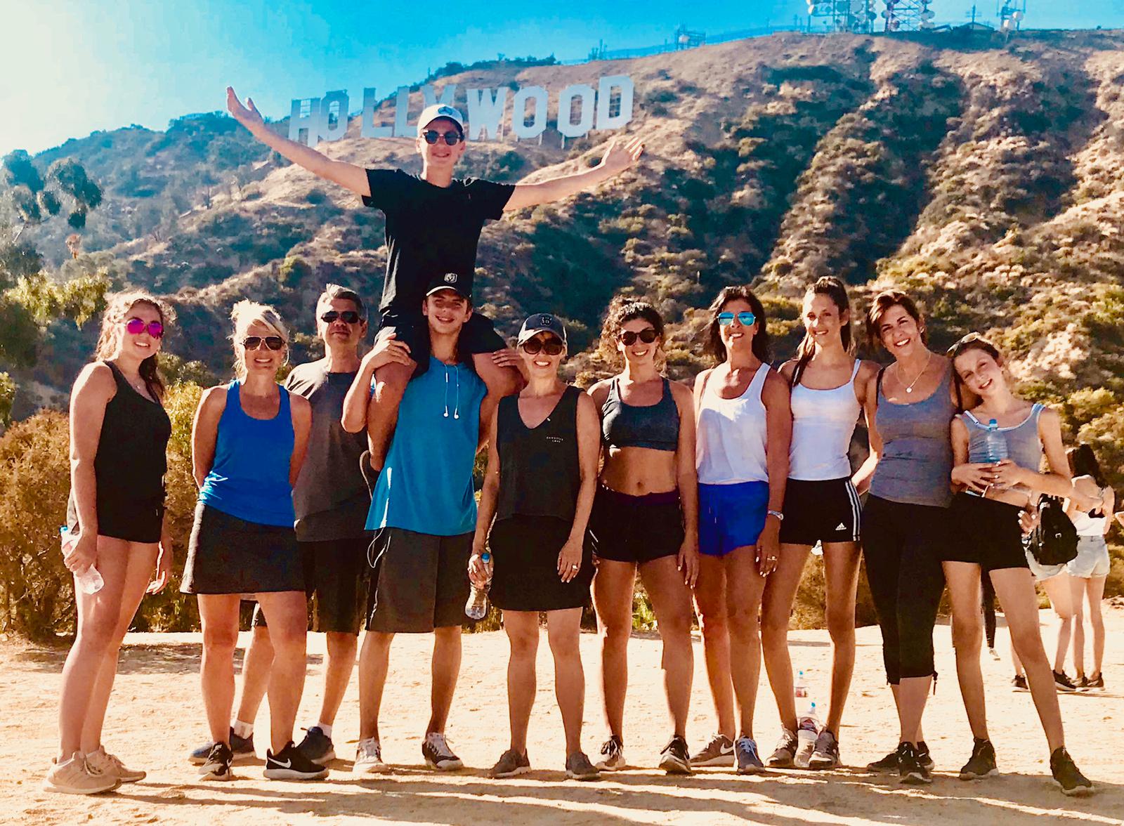 a group of people standing in front of a mountain