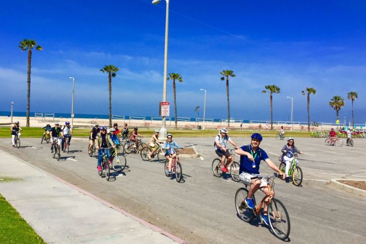 a group of people riding on the back of a bicycle