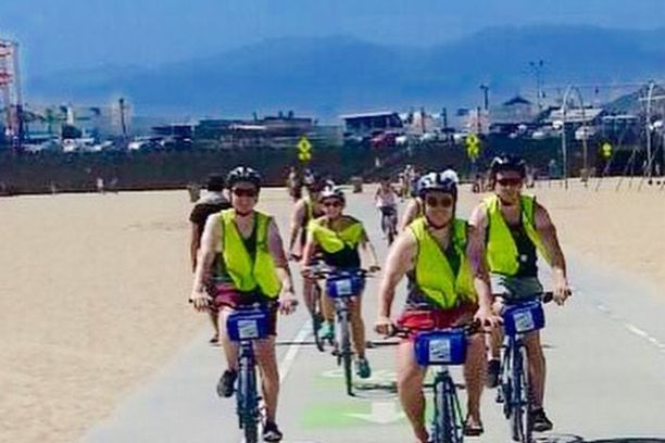 a group of people riding on the back of a bicycle