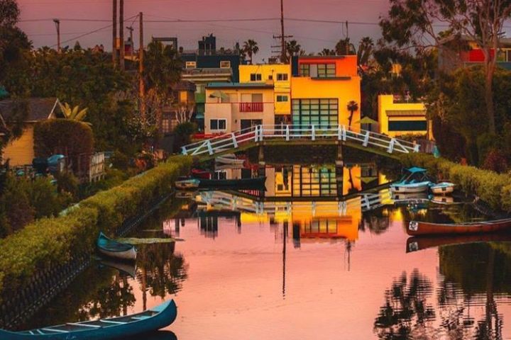 a sunset over a body of water with a city in the background