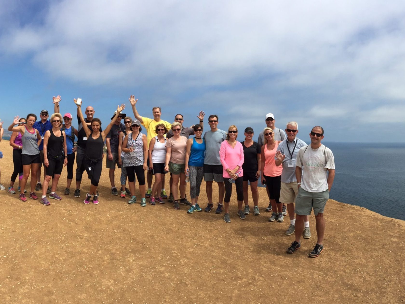 a group of people standing on a beach posing for the camera with Cadillac Ranch in the background