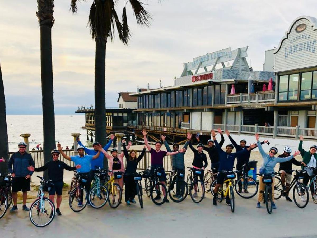 a group of people riding on bicycles on the beach