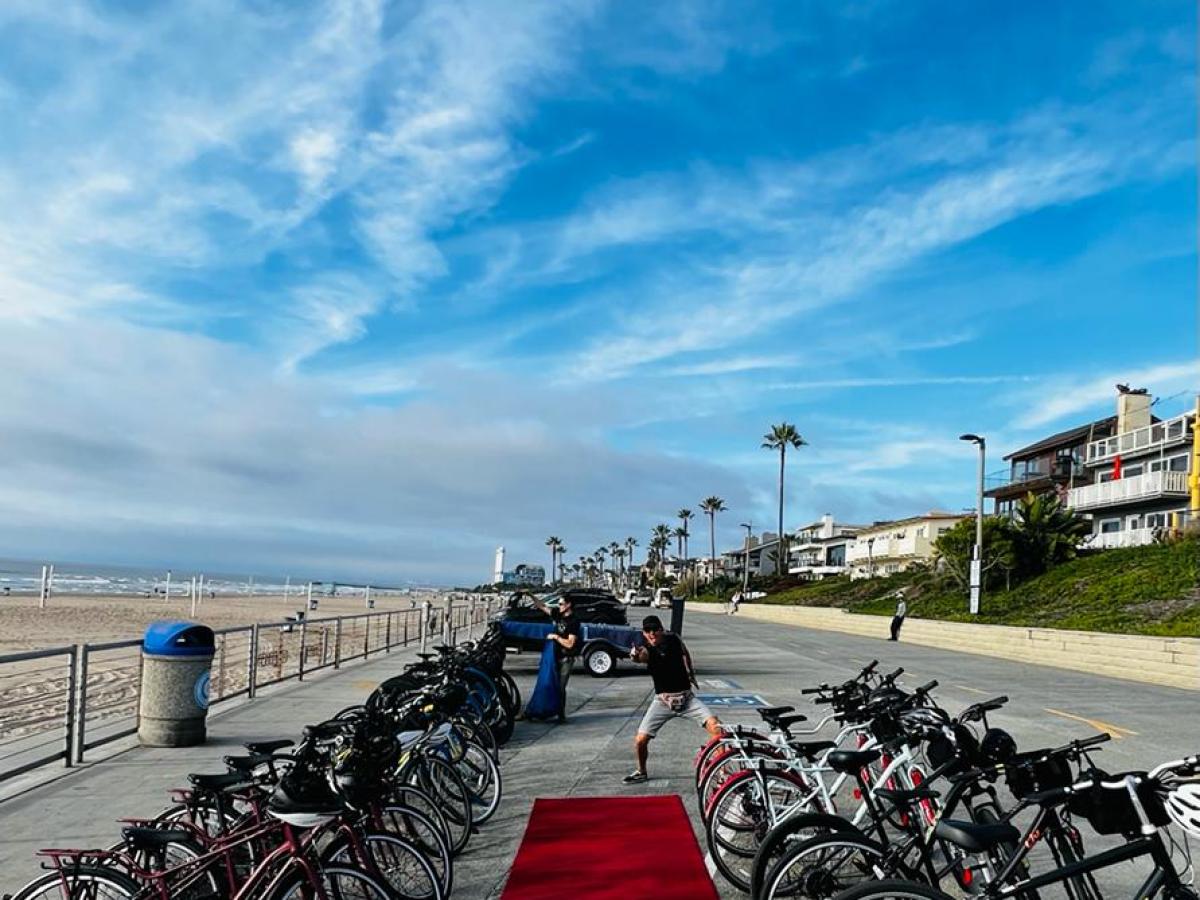 a group of bicycles lined up next to a red carpet by the beach