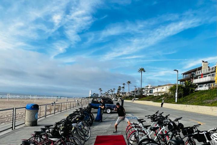 a group of bicycles lined up next to a red carpet by the beach