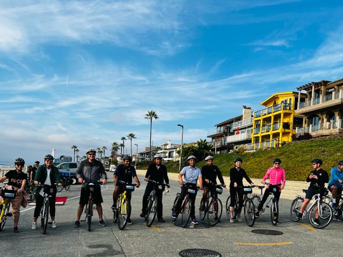 a group of people riding on bikes on the beach