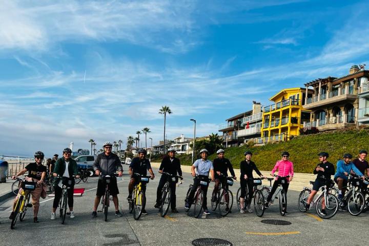 a group of people riding on bikes on the beach