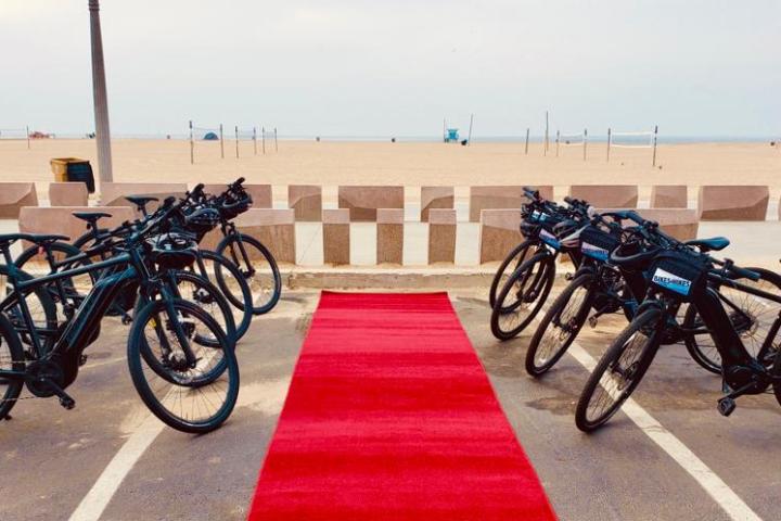 a group of bicycles parked by the beach with a red carpet