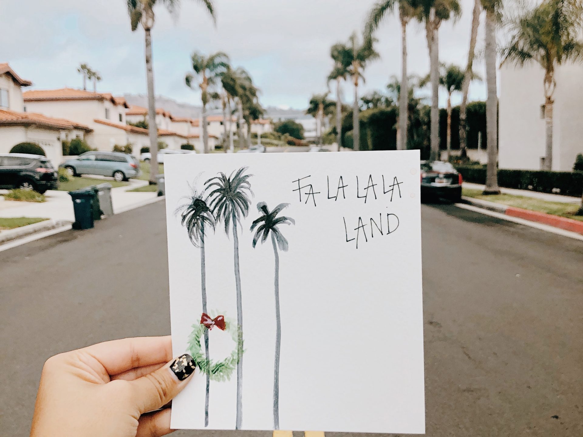 a person walking down a street next to a palm tree