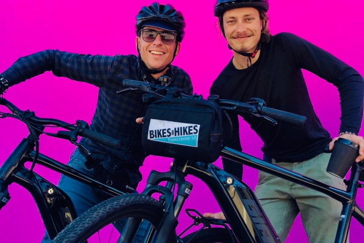 two people on bicycles next to the pink wall melrose