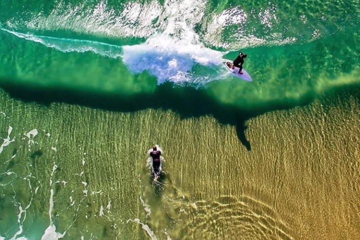 a man riding a wave on a surfboard in the water