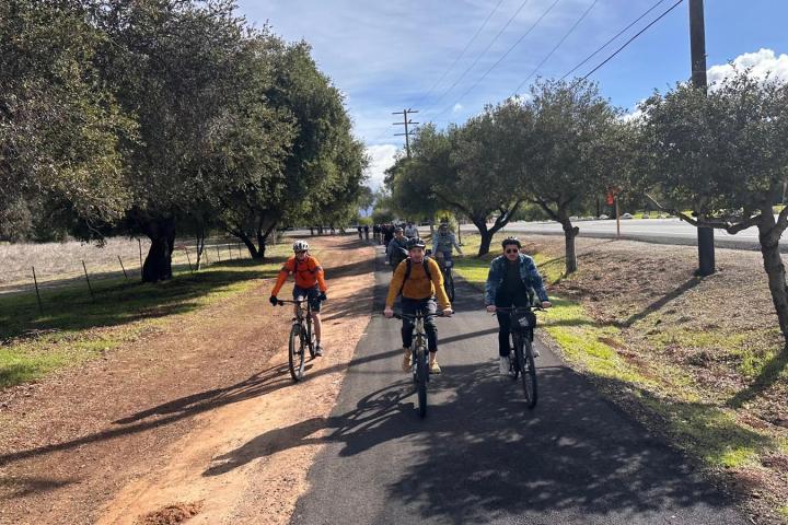 a man riding a bike down a dirt road