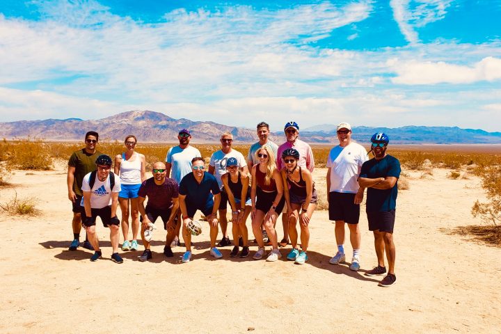 a group of people standing on top of a sandy beach