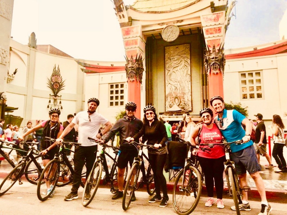 a group of people riding on the back of a bicycle