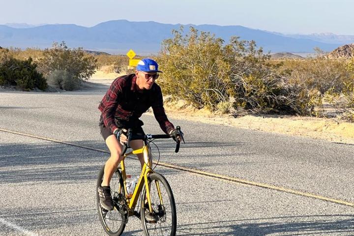a man riding a bike down a dirt road