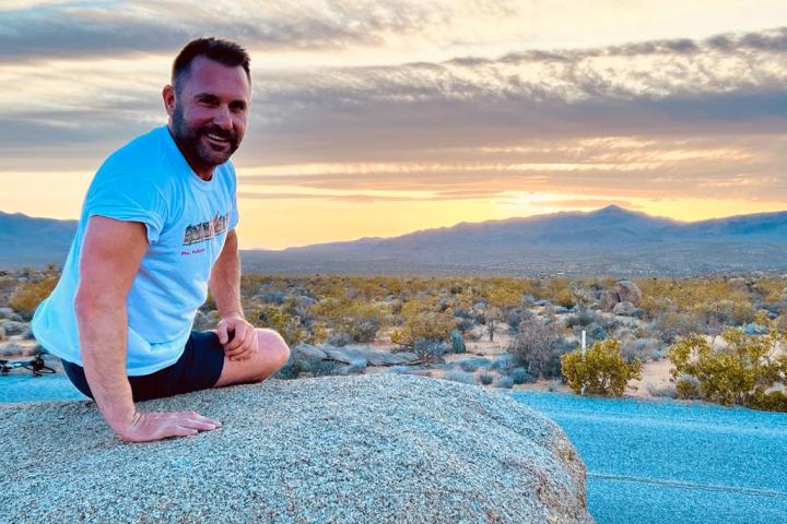 a man sitting next to a body of water