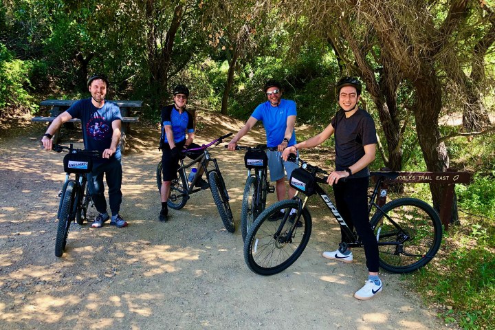 a group of people riding on the back of a bicycle on a group tour of westlake