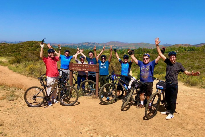 a group of people on a dirt road on a mountain bike tour westlake