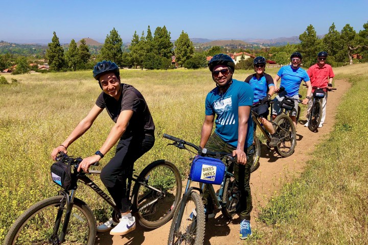 a group of people riding mountain bikes on a road in westlake