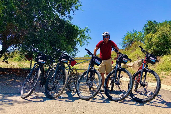 a person posing with a group of mountain bikes on a westlake tour