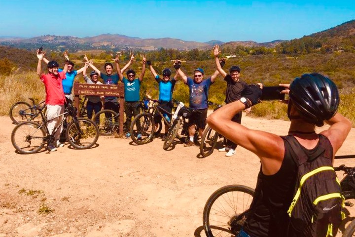 a group of people standing by bicycles on a group tour of westlake