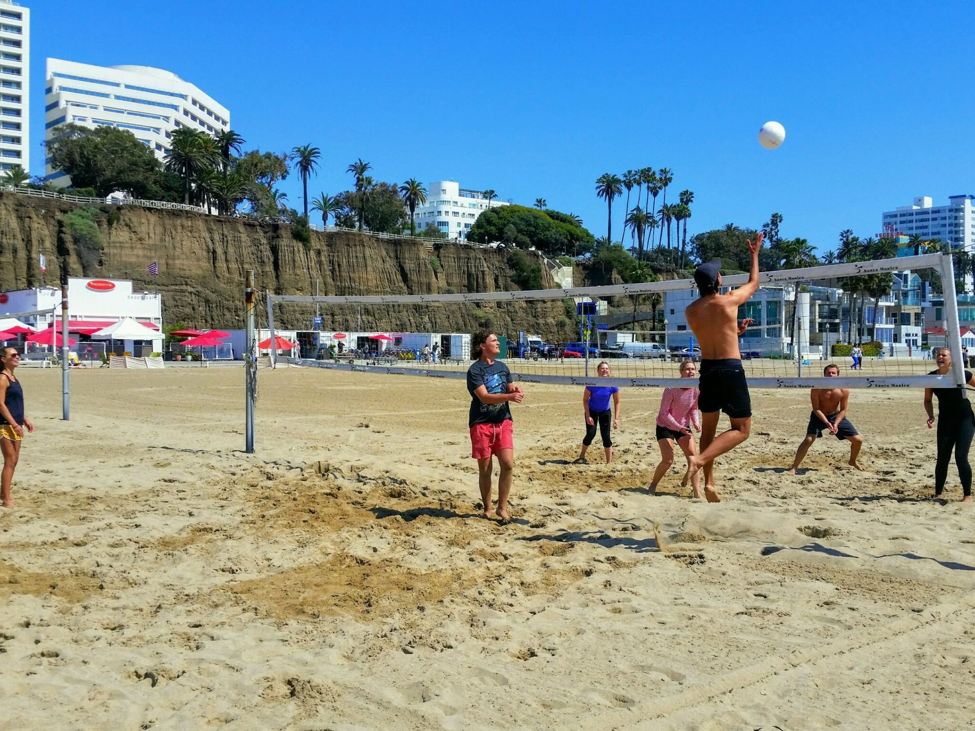 a group of people standing on top of a sandy beach