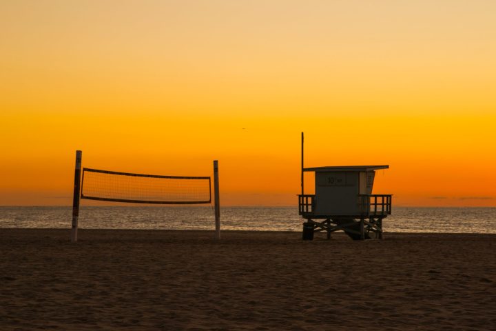 a sunset over a sandy beach next to the ocean