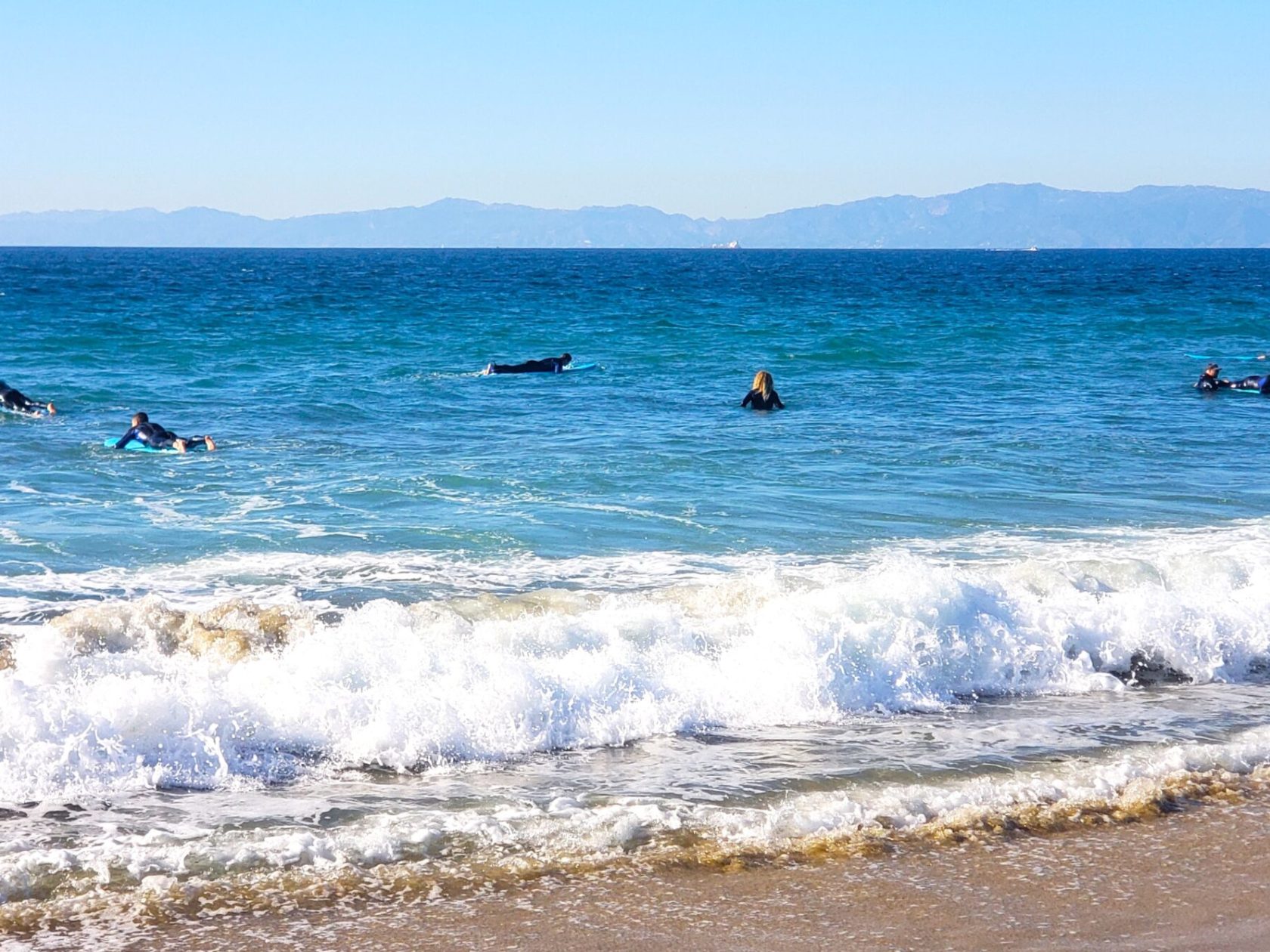 a group of people on a beach near a body of water