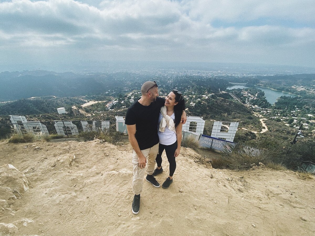 couple on the hollywood sign hike behind the sign