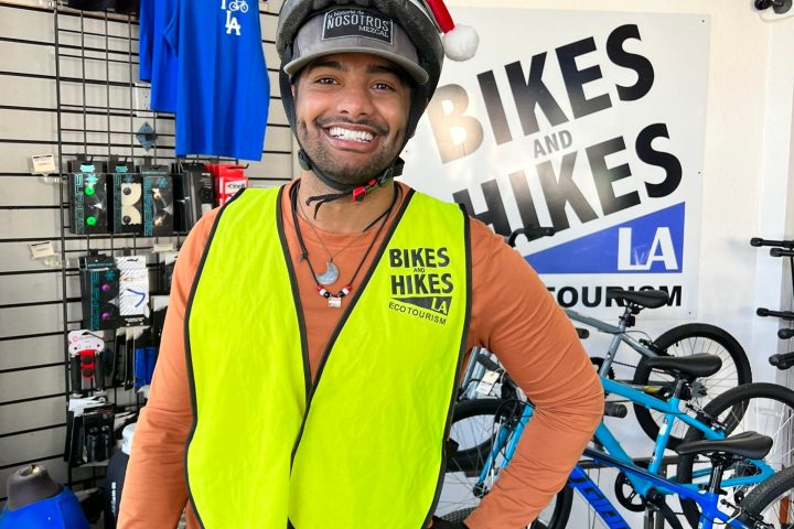 a person wearing a blue hat holding a bicycle