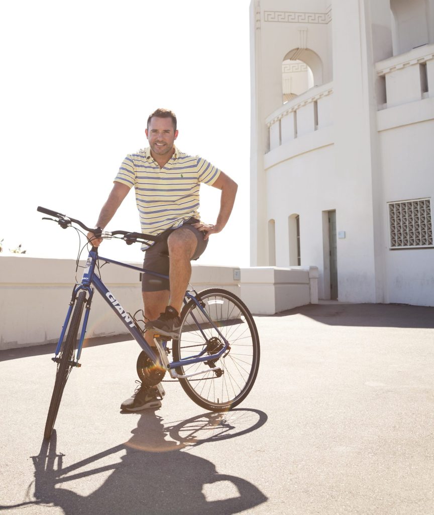 Brian McNamee riding on the back of a bicycle