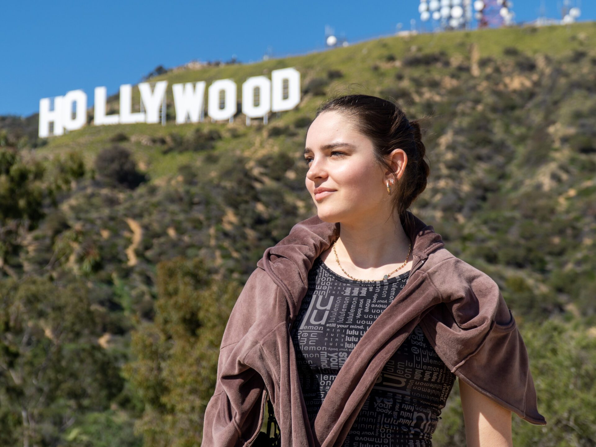 tourist posing in front of hollywood sign