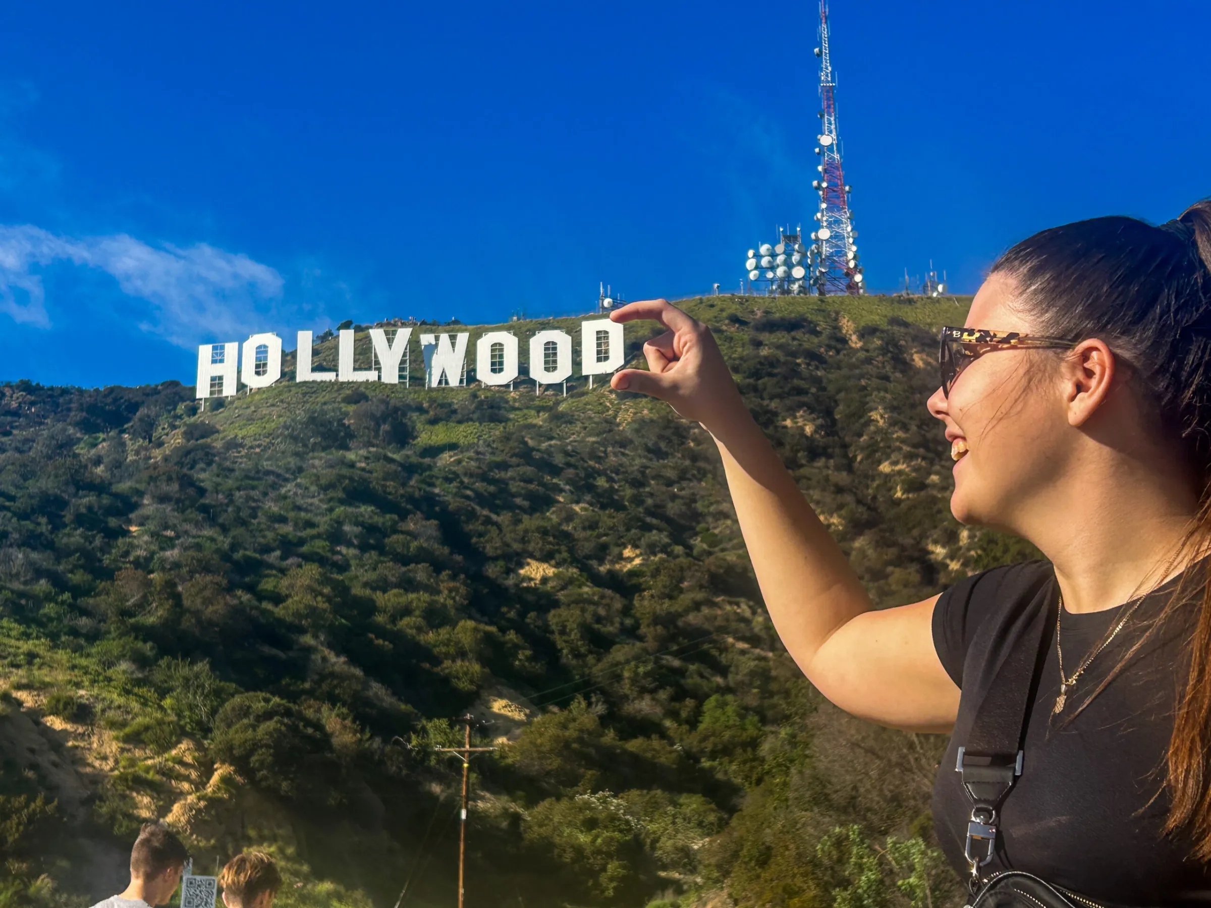 a person posing with Hollywood Sign in the background