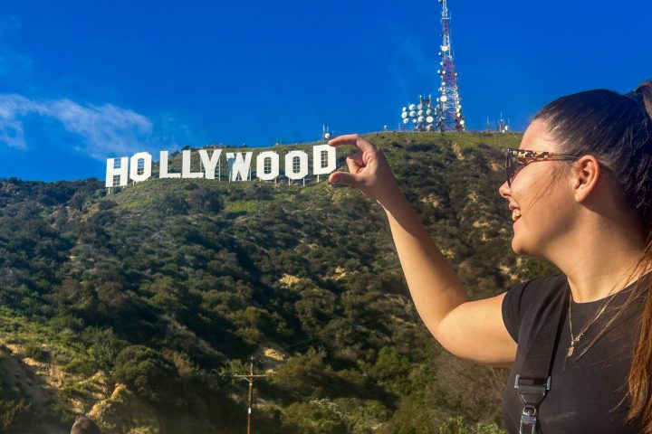 a person posing with Hollywood Sign in the background