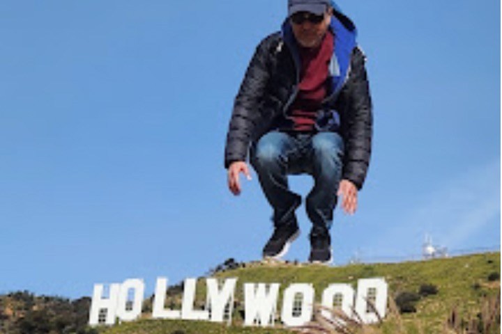 tourist jumping in front of hollywood sign
