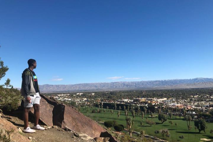 a person standing on top of a mountain on a palm springs hike