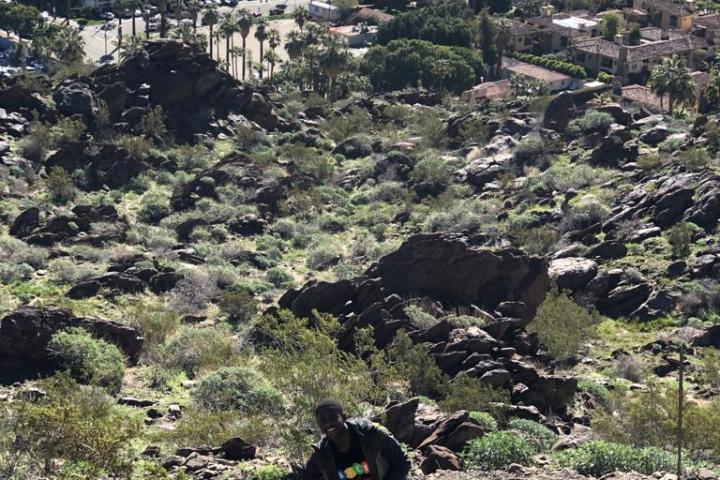 a man standing on a mountain overlooking downtown palm springs