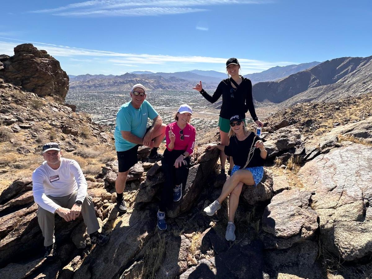 a group of people standing on a rocky hill
