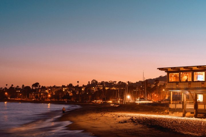 a sunset over a body of water with a city in the background