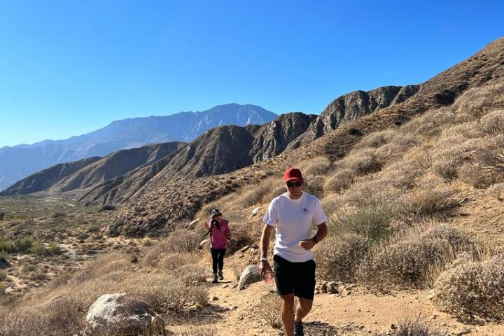 two people hike through the mountains on a palm springs group tour