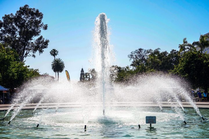 a fountain in front of a body of water