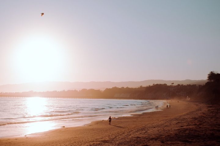 a group of people standing on top of a sandy beach