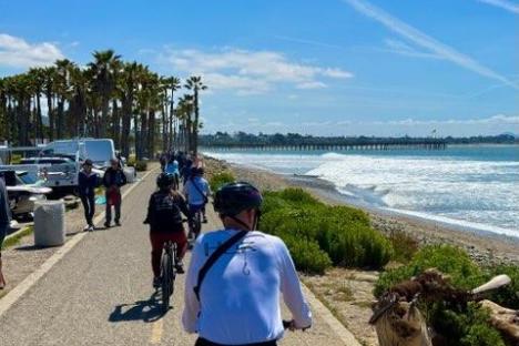 a group of people biking past a body of water on an ojai group tour