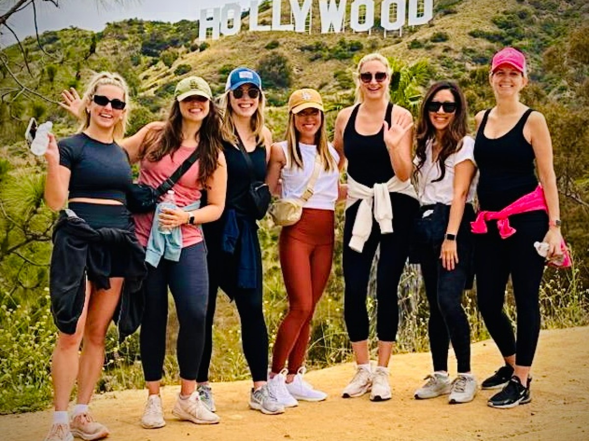 a group of people posing for a picture on a hollywood sign tour
