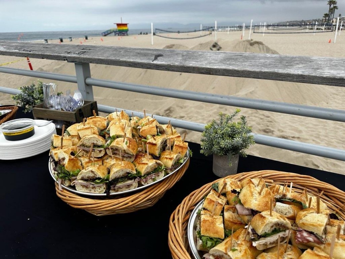 a plate of food on a picnic table by the beach on a bike food tour